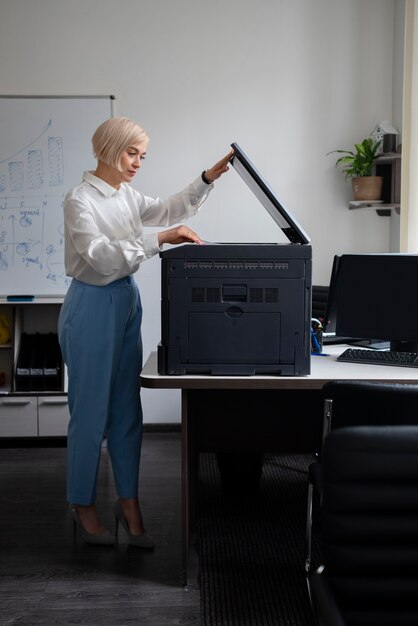 Mujer en el trabajo en la oficina usando impresora
