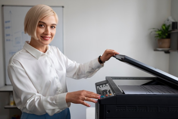 Mujer en el trabajo en la oficina usando impresora