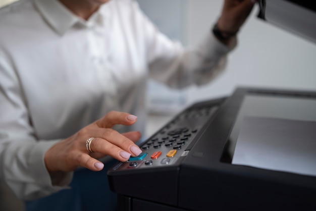 Mujer en el trabajo en la oficina usando impresora