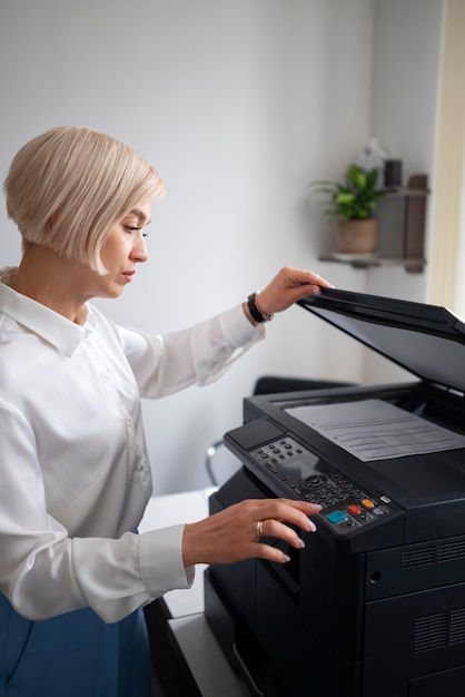 Foto gratuita mujer en el trabajo en la oficina usando impresora