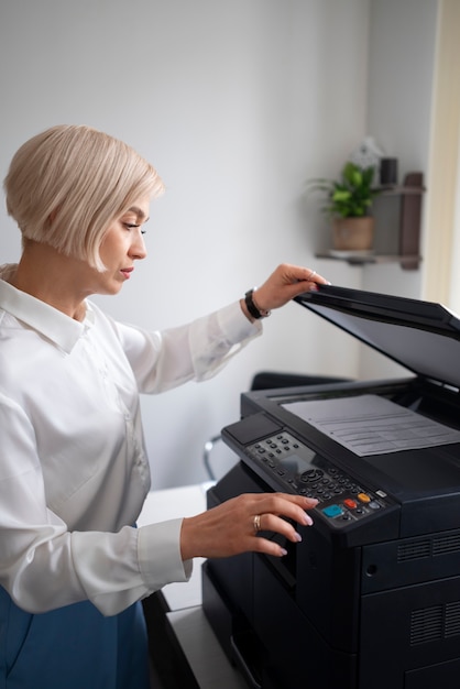 Mujer en el trabajo en la oficina usando impresora