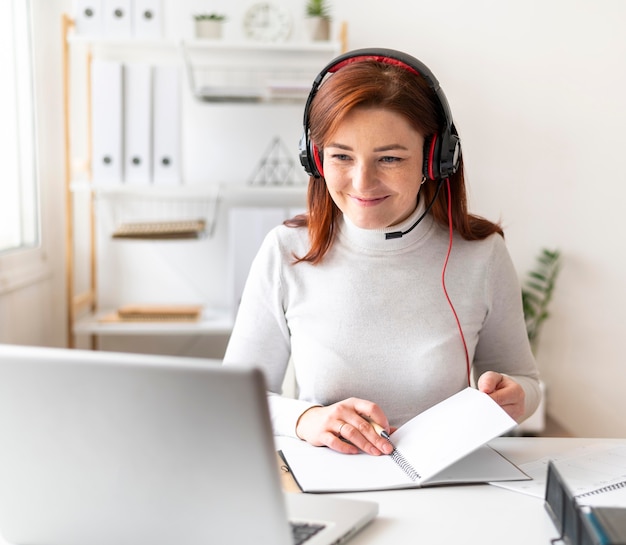 Foto gratuita mujer en el trabajo con videollamada