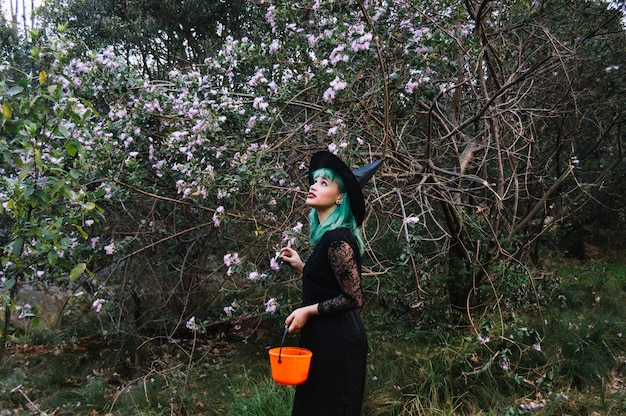 Mujer en traje en el árbol floreciente
