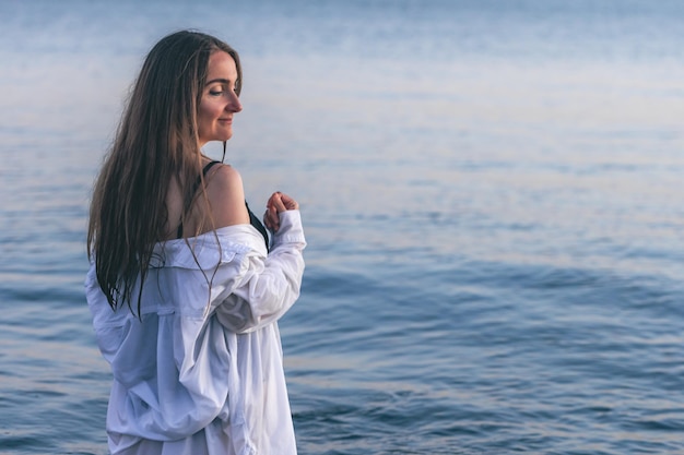 Foto gratuita una mujer en traje de baño y una camisa blanca en el mar.