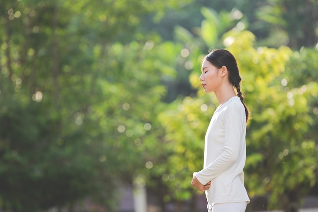 Mujer en traje blanco meditando en la naturaleza