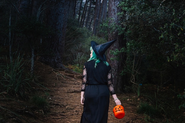 Mujer en traje de bruja en el bosque
