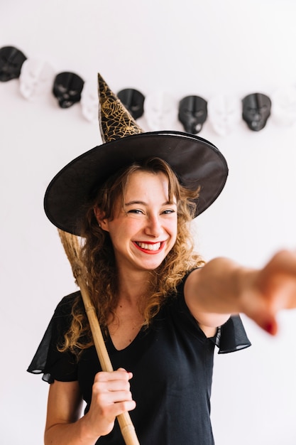 Foto gratuita mujer en traje de bruja con escoba negra