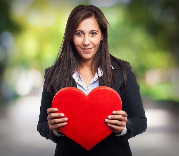 Mujer con traje y un corazón en las manos