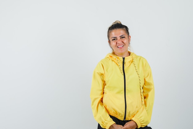 Mujer en traje deportivo y mirando alegre, vista frontal.