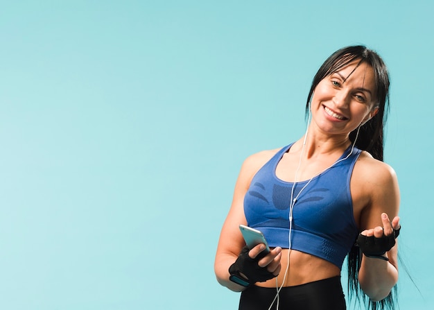 Mujer en traje de gimnasio disfrutando de la música en los auriculares