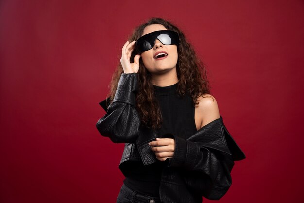 Mujer en traje negro con gafas negras.