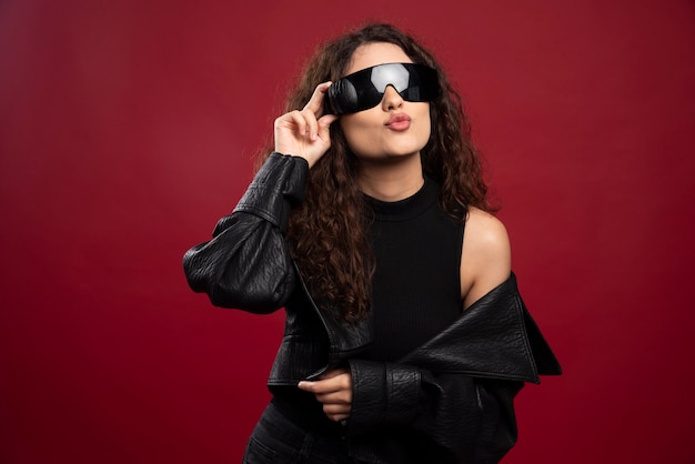 Foto gratuita mujer en traje negro con gafas negras.