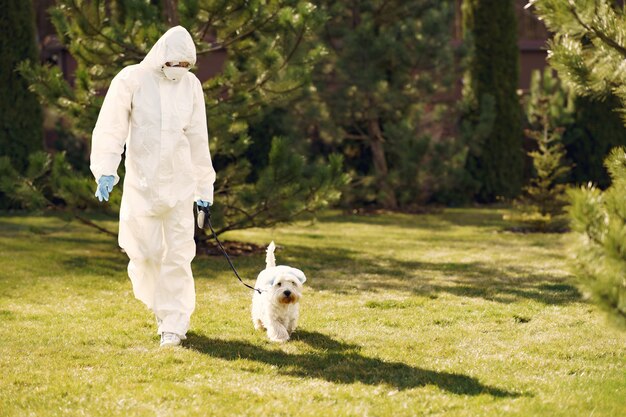 Mujer en un traje protector caminando con un perro