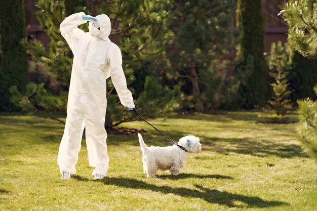 Mujer en un traje protector caminando con un perro