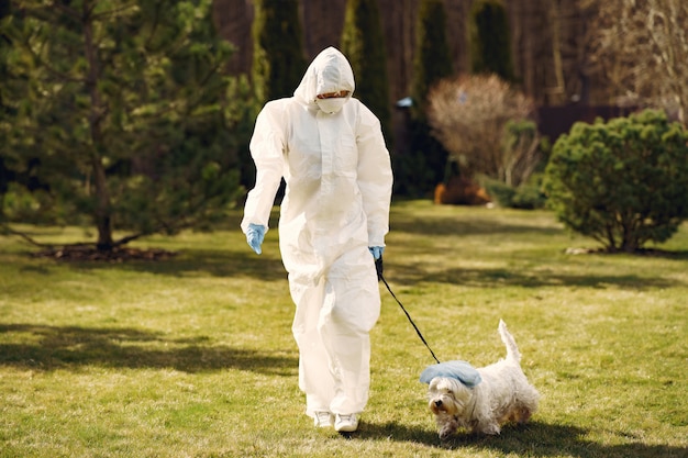 Mujer en un traje protector caminando con un perro