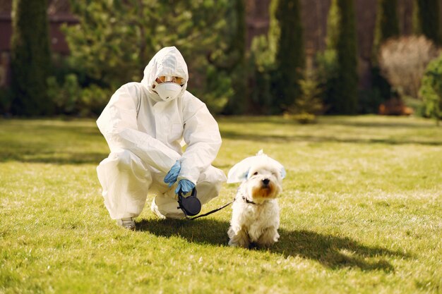 Mujer en un traje protector caminando con un perro