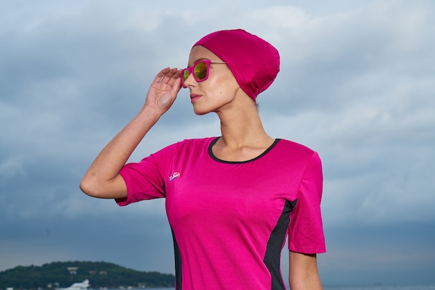 Mujer con traje rosa y pañuelo para la cabeza rosa