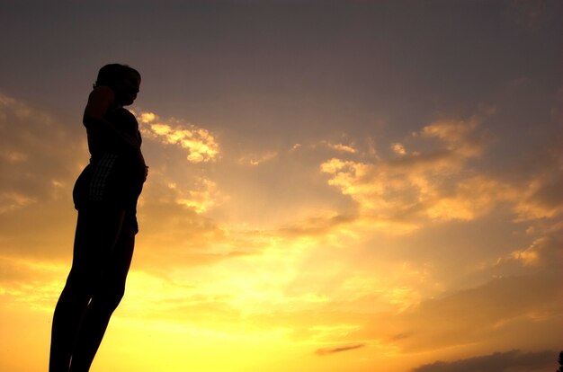 Mujer tranquila con el cielo de fondo en tonos de naranja