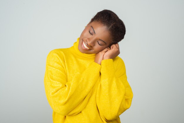 Mujer tranquila disfrutando suéter amarillo