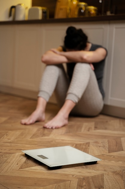 Foto gratuita mujer con trastorno alimentario llorando junto a una escala