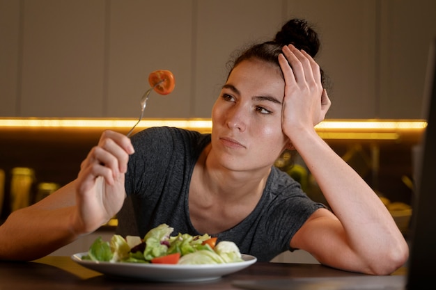 Mujer tratando de comer sano en casa