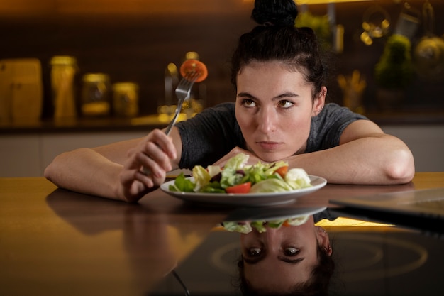 Mujer tratando de comer sano en casa