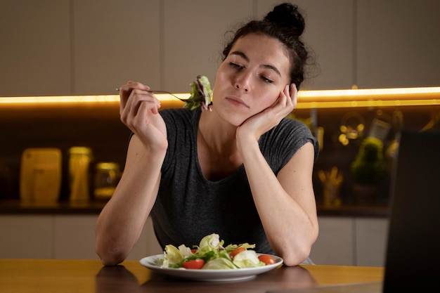Mujer tratando de comer sano en casa