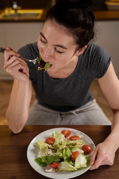 Foto gratuita mujer tratando de comer sano en casa