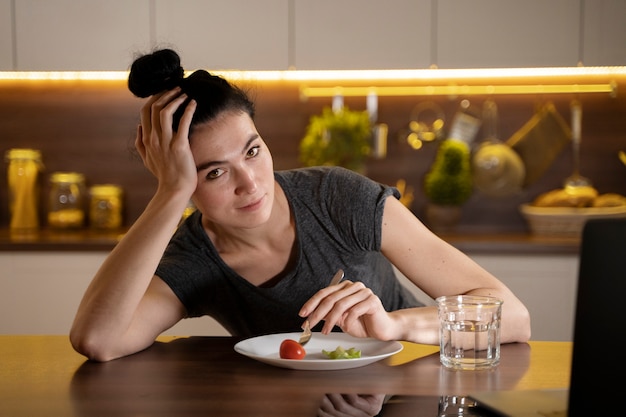 Mujer tratando de comer sano en casa