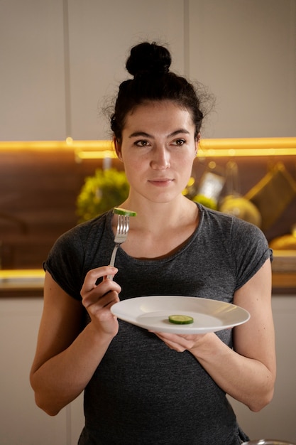 Mujer tratando de comer sano en casa