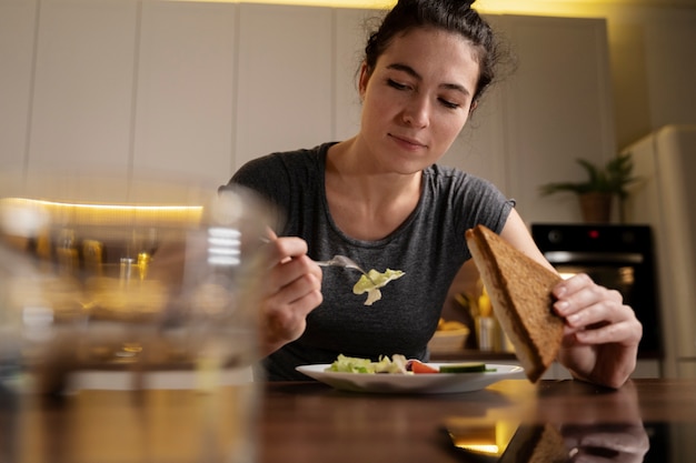 Mujer tratando de comer sano en casa