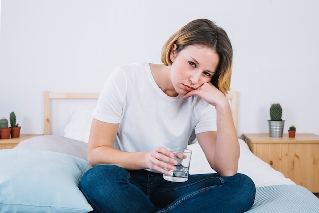 Mujer triste con agua mirando a la cámara