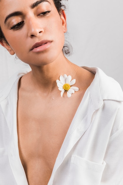 Foto gratuita mujer triste atractiva con la flor cerca del cuello