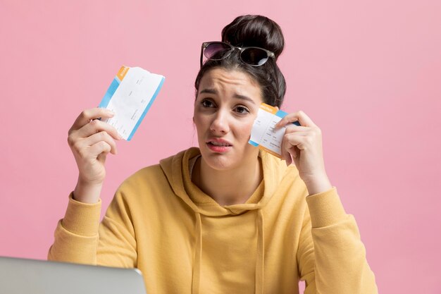 Mujer triste mientras sostiene un billete de avión rasgado