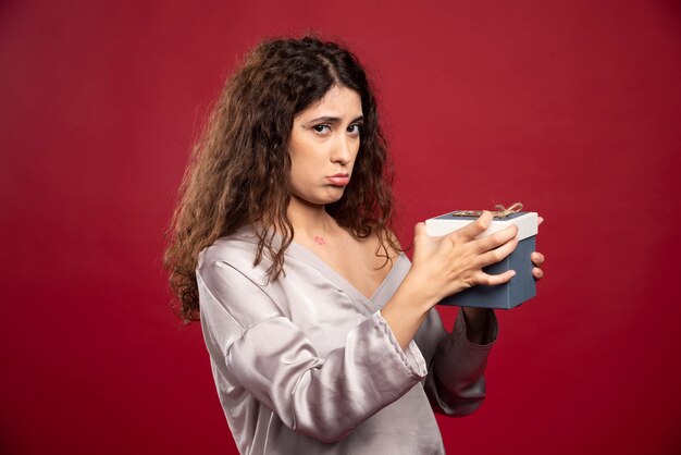 Mujer triste que sostiene la caja vacía.