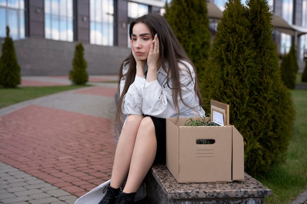 Foto gratuita mujer triste de tiro completo con caja de cartón