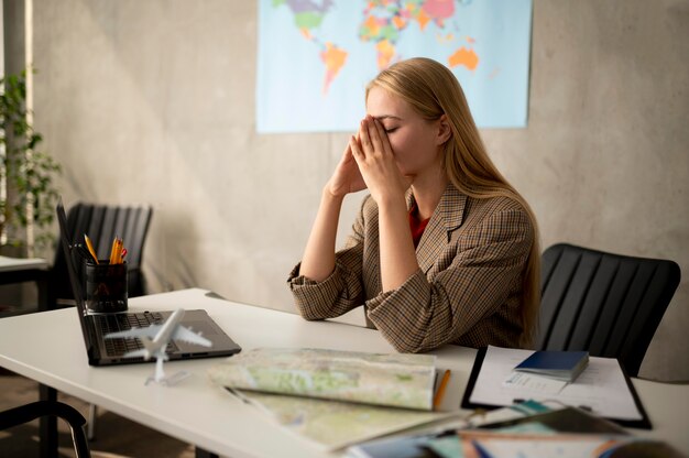 Mujer triste de tiro medio en agencia de viajes