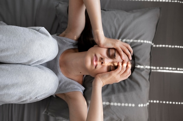 Mujer triste de tiro medio en la almohada