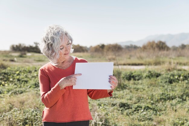 Mujer con trozo de papel al aire libre