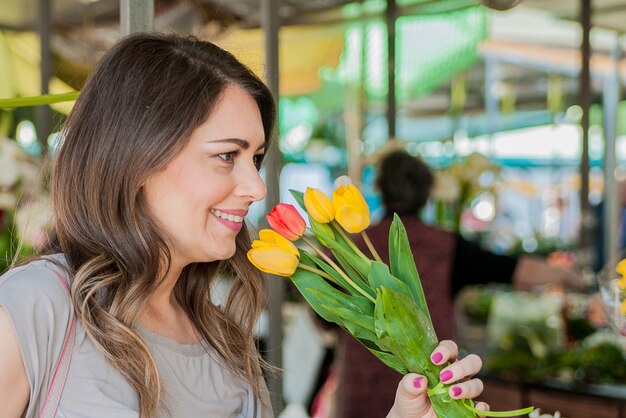 Mujer con tulipanes. Hermosa mujer con flores. Delicada y hermosa mujer que huele tulipanes