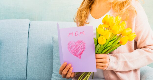 Mujer con tulipanes y postal para el día de la madre.