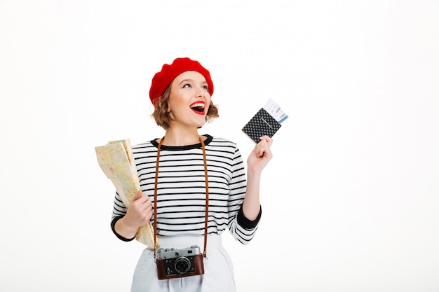 Mujer turista feliz con cámara con mapa y pasaporte