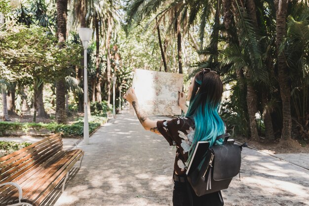 Mujer turista mirando el mapa en el parque