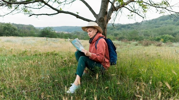 Mujer turista senior en la naturaleza con mapa