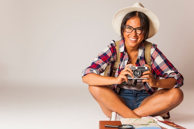 Foto gratuita mujer turista sonriente sentada con cámara