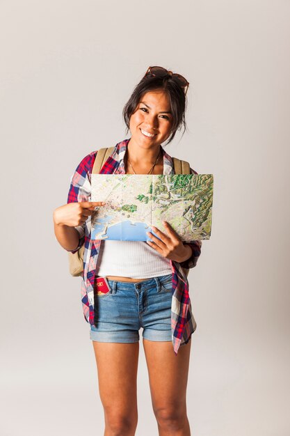 Mujer turista sonriente sujetando mapa