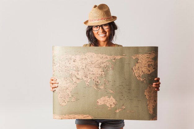 Mujer turista sujetando mapa del mundo