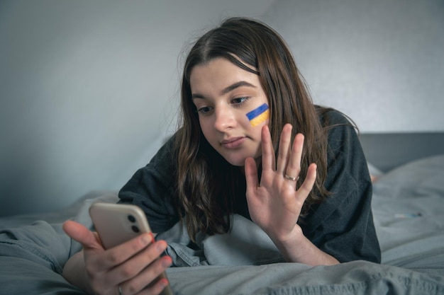 Una mujer ucraniana con una bandera pintada en la cara se comunica a través de un enlace de video