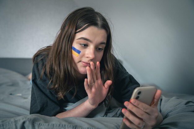 Foto gratuita una mujer ucraniana con una bandera pintada en la cara se comunica a través de un enlace de video