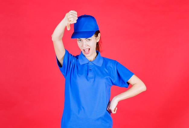 Mujer en uniforme azul mostrando signo de aversión.